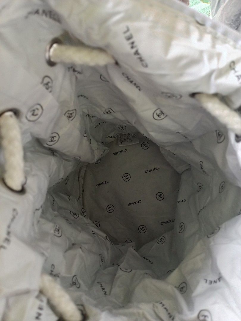Chanel Bucket Bag (Category: Luxury Bags & Wallets) located in Polomolok. Submitted by delosreyesshyn81134 (Listing ID 1421761191, Image 3). Description: - Black bucket bag - White "CHANEL" logo - Drawstring closure with white rope - Chanel logo patterned lining - Brown trim at the bottom.