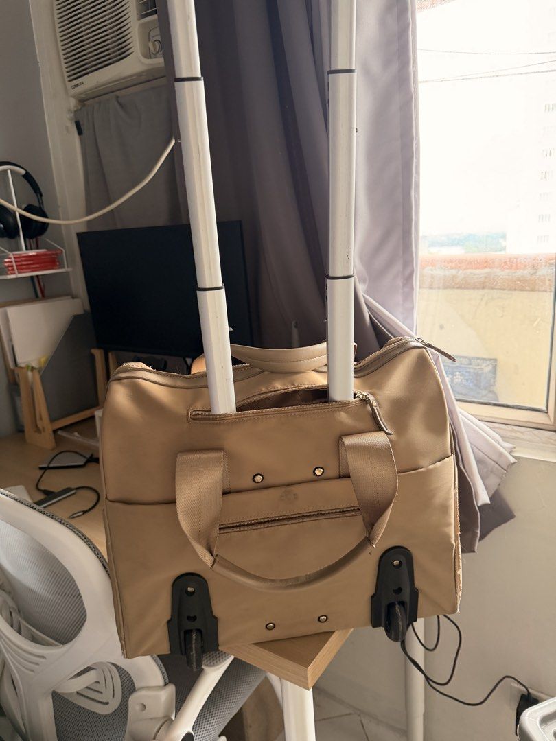 CLN Rolling Bag (Category: Luxury Bags & Wallets) located in Manila. Submitted by ellede32655 (Listing ID 1421653157, Image 3). Description: - CLN tan rolling bag - Top handle and shoulder strap - Wheels for easy transport - Multiple zippered compartments - Includes luggage tag - Shows wear and tear on corners and seams.