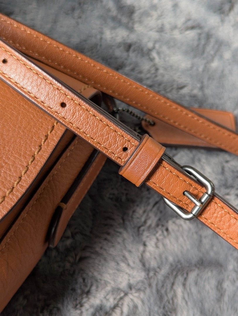 Coach Saddle Crossbody Bag (Category: Luxury Bags & Wallets) located in Manila. Submitted by eladp (Listing ID 1421730035, Image 3). Description: - Authentic Coach crossbody bag -Preloved RETAIL item - Saddle bag design - Tan leather exterior - Adjustable strap - Magnetic snap closure - Includes Coach hangtag - Interior zippered pocket - Additional slip pocket.