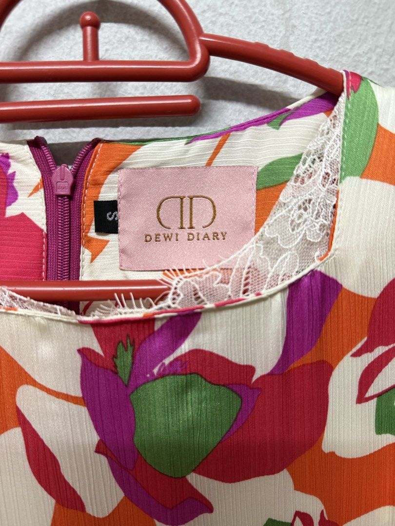 Dewi Diary (Category: Baju Kurung & sets) located in Cheras. Submitted by n_sai (Listing ID 1421702213, Image 2). Description: - Brand: Dewi Diary - Size: S - Features a colorful floral print (orange, pink, green) - Design: Round neckline with lace detailing, long sleeves - Closure: Zipper at the back.