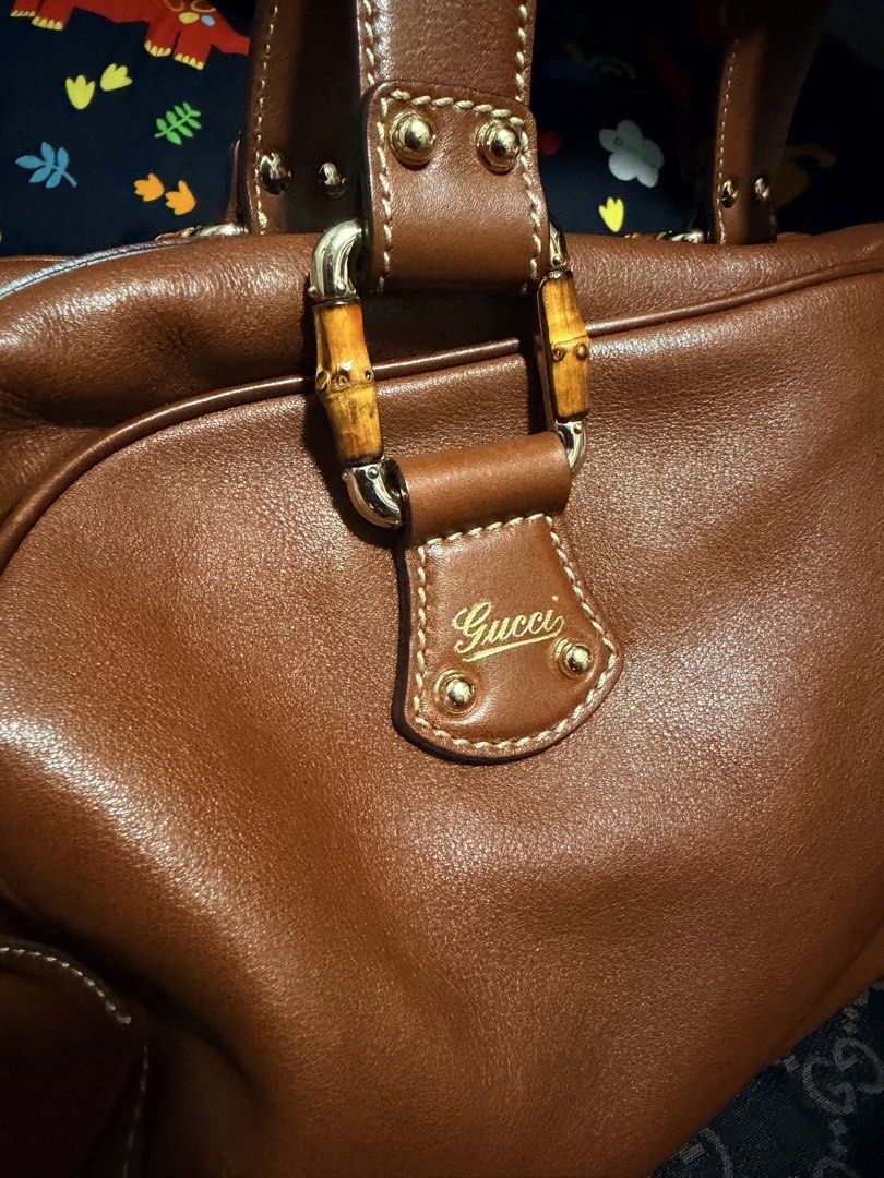 Gucci Bamboo Boston (Category: Luxury Bags & Wallets) located in Mandaluyong City. Submitted by marsemars (Listing ID 1421633971, Image 2). Description: - Authentic Gucci handbag - Bamboo handles - Brown leather exterior - Gold-tone hardware - Zipper closure with bamboo charm - Structured shape - Stitched design - Gucci logo visible - Well-maintained.