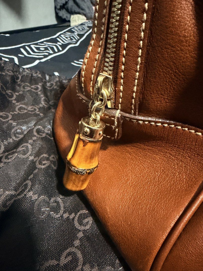 Gucci Bamboo Boston (Category: Luxury Bags & Wallets) located in Mandaluyong City. Submitted by marsemars (Listing ID 1421633971, Image 3). Description: - Authentic Gucci handbag - Bamboo handles - Brown leather exterior - Gold-tone hardware - Zipper closure with bamboo charm - Structured shape - Stitched design - Gucci logo visible - Well-maintained.