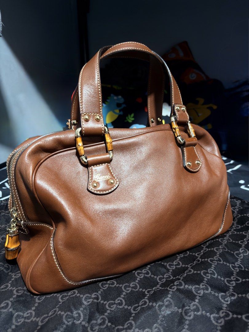 Gucci Bamboo Boston (Category: Luxury Bags & Wallets) located in Mandaluyong City. Submitted by marsemars (Listing ID 1421633971, Image 1). Description: - Authentic Gucci handbag - Bamboo handles - Brown leather exterior - Gold-tone hardware - Zipper closure with bamboo charm - Structured shape - Stitched design - Gucci logo visible - Well-maintained.