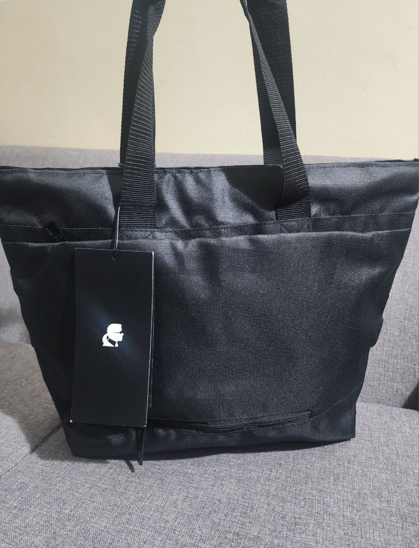 Karl Lagerfeld Black Polyester Canvas Tote Bag (Category: Tote Bags) located in Quezon City. Submitted by sebbysgoodsfromusa (Listing ID 1421686541, Image 2). Description: - Karl Lagerfeld black tote bag - Zippered main compartment - Exterior pocket - Interior pockets for organization - Karl Lagerfeld logo on front - Includes tag - Made in Thailand Bag can be used for luggage (provision to insert in luggage bag trolley handle) Approximate dimensi