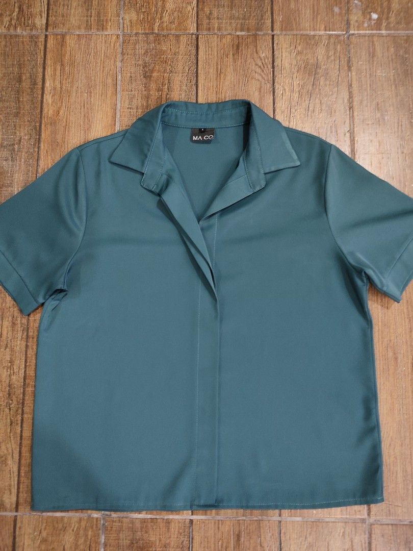 MA CO Teal Short Sleeve Top (Category: Blouses) located in Dasmarinas. Submitted by sbtt_ (Listing ID 1421639674, Image 3). Description: - MA CO. teal short sleeve top - Collared neckline - Button-down design - Relaxed fit - Smooth, likely synthetic fabric - Solid teal color - Brand tag visible.