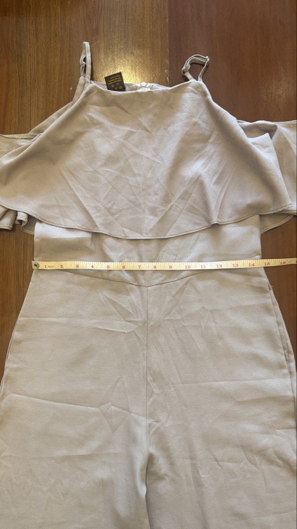 Mags Off-Shoulder Jumpsuit - Size M (Category: Jumpsuits) located in Cebu City. Submitted by marginiz (Listing ID 1421673215, Image 2). Description: Elegant off-shoulder jumpsuit from Mags. Features a flattering design with wide-leg pants and delicate spaghetti straps. The jumpsuit is a neutral color, suitable for various occasions. Size M. The waist measures approximately 14 inches across. The total length is approximately 53 inches. It has a zi
