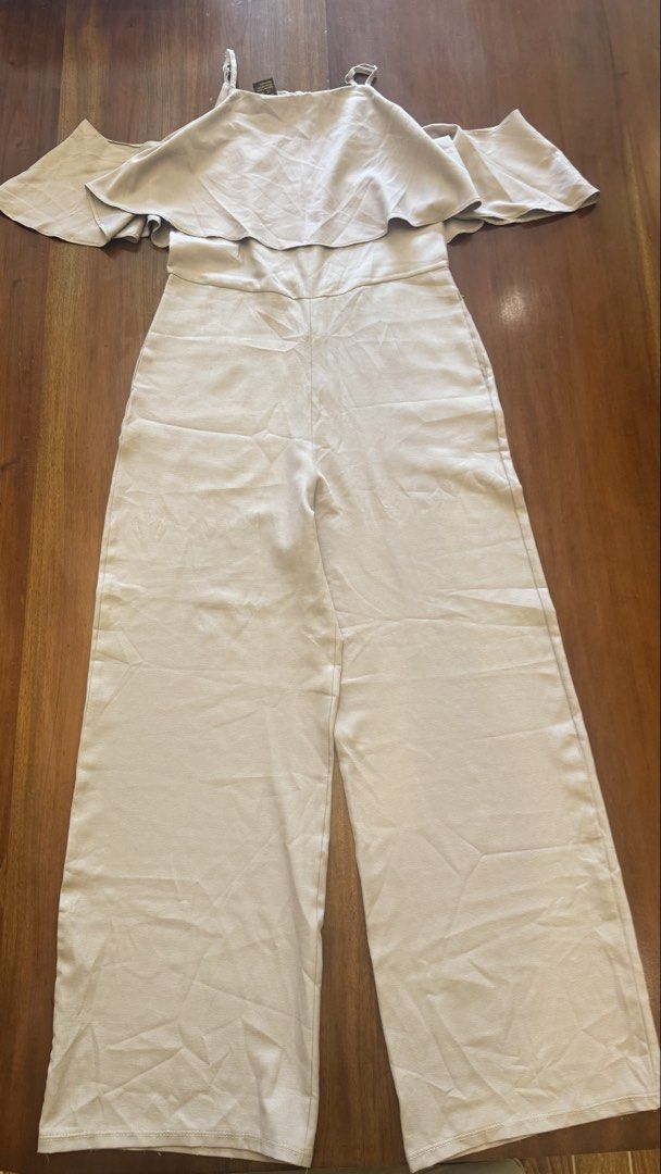 Mags Off-Shoulder Jumpsuit - Size M (Category: Jumpsuits) located in Cebu City. Submitted by marginiz (Listing ID 1421673215, Image 1). Description: Elegant off-shoulder jumpsuit from Mags. Features a flattering design with wide-leg pants and delicate spaghetti straps. The jumpsuit is a neutral color, suitable for various occasions. Size M. The waist measures approximately 14 inches across. The total length is approximately 53 inches. It has a zi