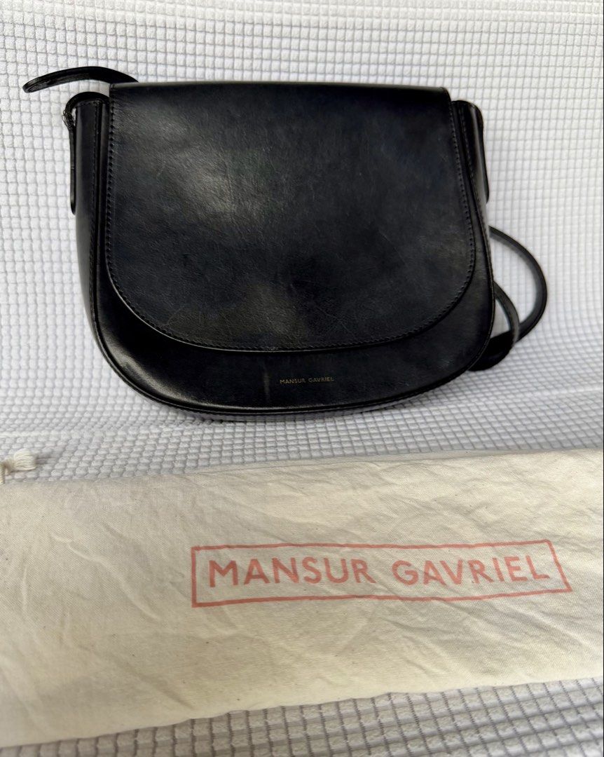 Mansur Gavriel Black Leather Crossbody Bag (Category: Luxury Bags & Wallets) located in Manila. Submitted by mr.arnie (Listing ID 1421748057, Image 2). Description: Black leather crossbody bag from Mansur Gavriel. Features a flap closure and an adjustable shoulder strap. Includes a dust bag. The interior has a slip pocket. Made in Italy. The bag has the Mansur Gavriel logo embossed on the front..