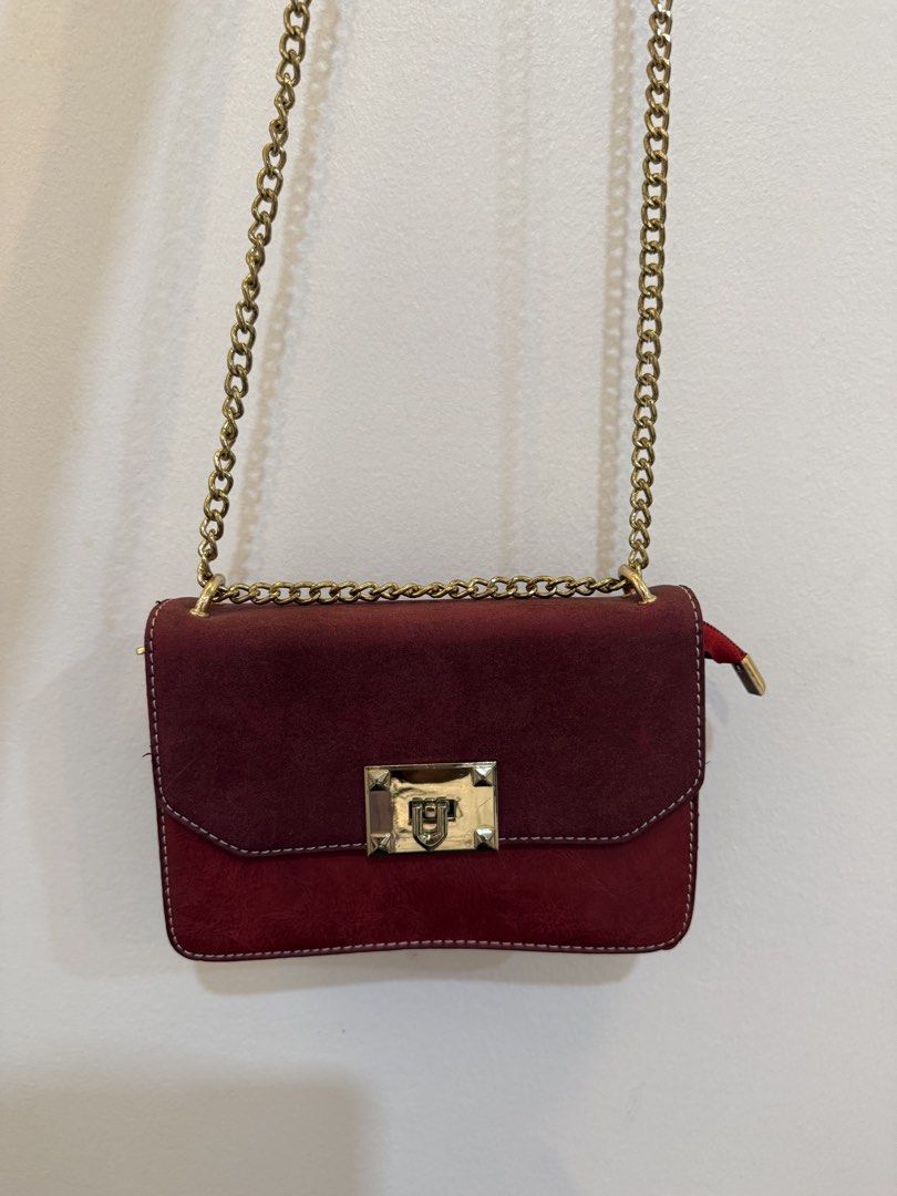 Maroon Shoulder Bag with Gold Chain (Category: Shoulder Bags) located in Quezon City. Submitted by reeseberrychic (Listing ID 1421642455, Image 2). Description: - Maroon shoulder bag - Gold chain strap - Gold-colored clasp - Two-tone design (darker flap, lighter body) - Visible stitching - Small side zipper.