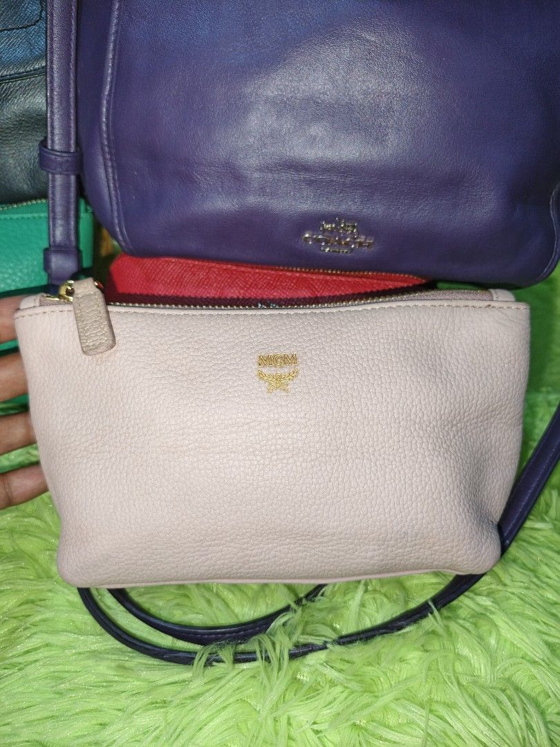 MCM Crossbody Pouch (Category: Luxury Bags & Wallets) located in Davao. Submitted by ukaystuff07 (Listing ID 1421781130, Image 1). Description: - Authentic MCM crossbody pouch - Light pink color - Gold-tone zipper - MCM logo on front - Pink satin-like interior lining - Includes MCM tag - Comes with a strap for easy carrying -issue :light faded parts upper part near zipper.