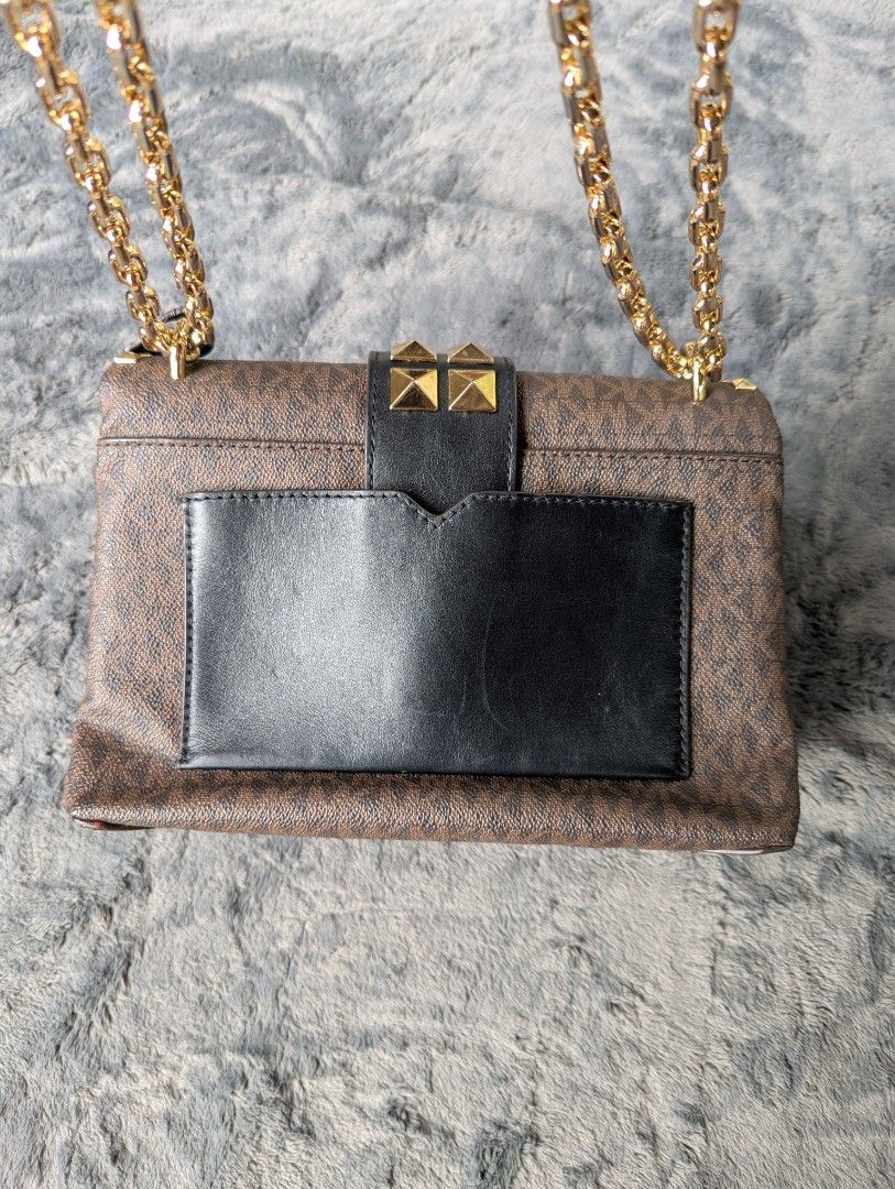 Michael Kors Studded Shoulder Bag (Category: Luxury Bags & Wallets) located in Manila. Submitted by eladp (Listing ID 1421726865, Image 3). Description: - Michael Kors Cece shoulder bag -preloved - Brown monogram pattern - Gold-tone hardware - Chain strap - Adorned with gold studs - Black leather flap - Zippered interior pocket - Brown fabric lining - Magnetic closure ❌No to low ballers.