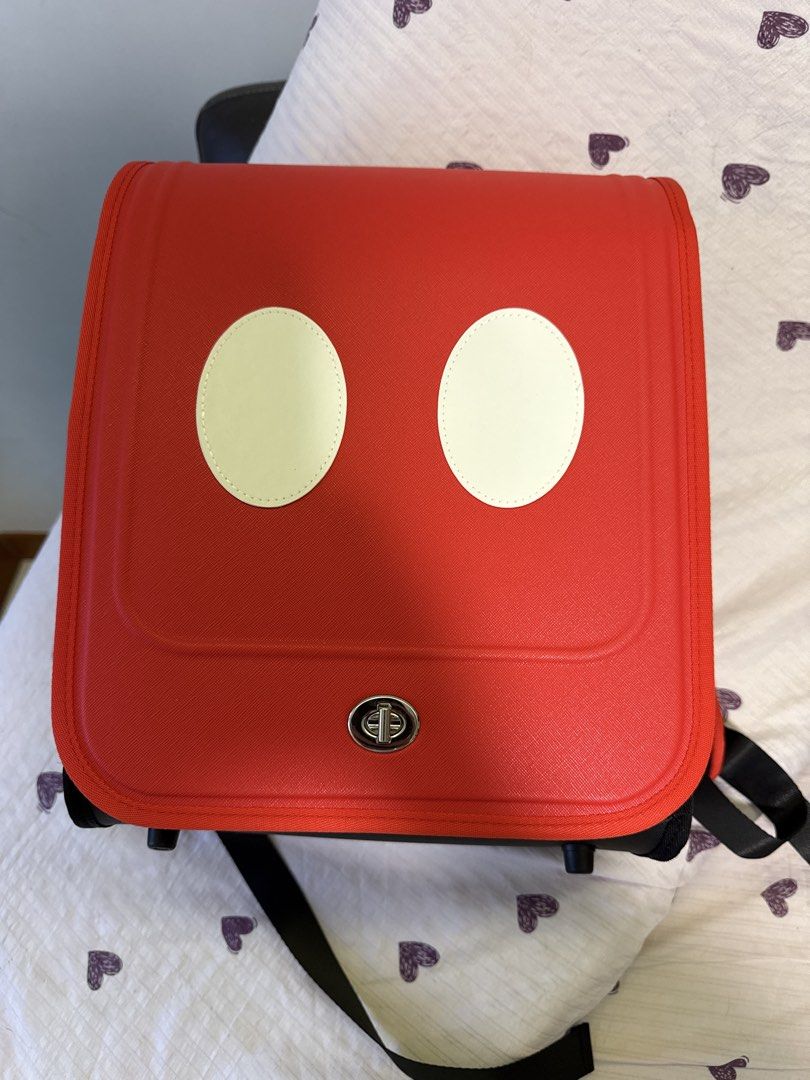 Mickey Mouse Red Backpack (Category: Backpacks) located in Singapore. Submitted by chaserbae (Listing ID 1421720313, Image 1). Description: - Adorable red backpack with Mickey Mouse design. - Features two white circles resembling Mickey's face. - Secure clasp for safety. - Adjustable straps for comfort. - Perfect for carrying essentials in style!.