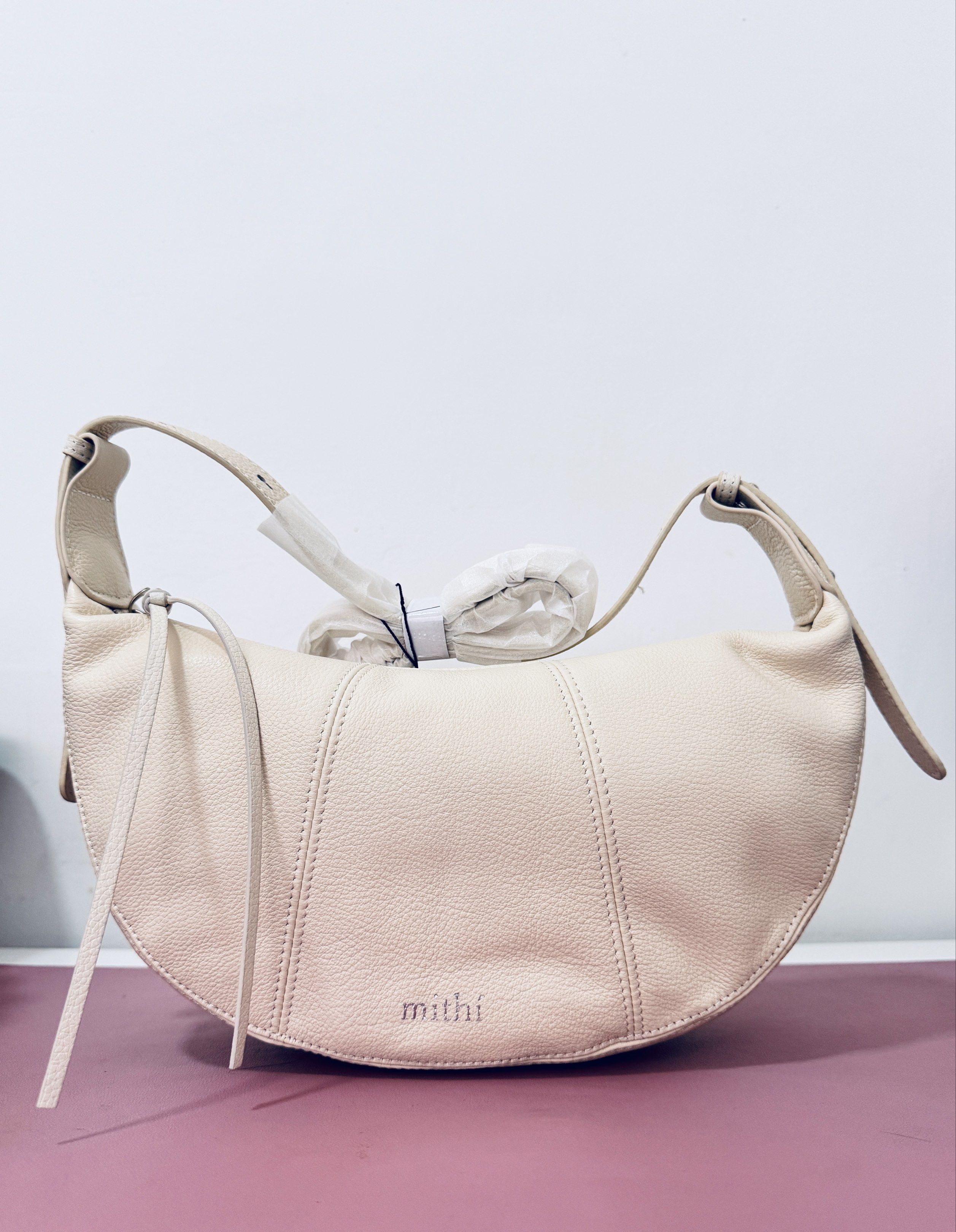 Mithi Crescent Bag (cowhide leather) 2pcs left (Category: Luxury Bags & Wallets) located in Cavite. Submitted by may.tag (Listing ID 1421662605, Image 1). Description: - Mithi crescent bag - Unique half-moon shape - Light cream exterior - Shoulder strap and top handle - Zipper closure - Small tassel detail - Made of genuine cowhide leather.