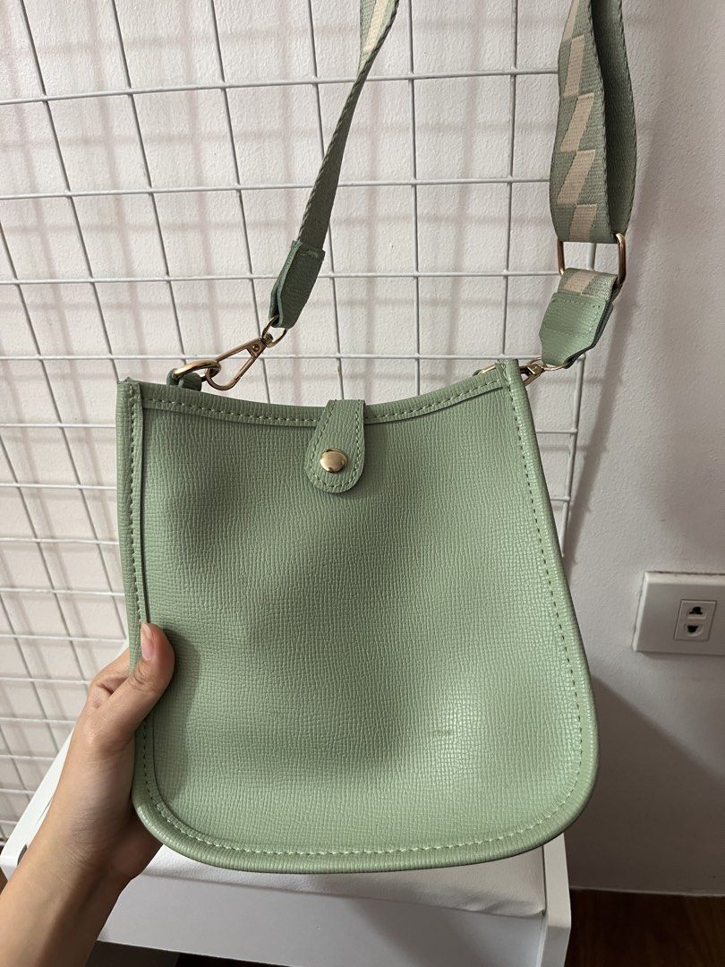 Parisian Green Crossbody Bag (Category: Cross-body Bags) located in Antipolo. Submitted by sldchloe_declutters (Listing ID 1421645838, Image 1). Description: - Stylish green crossbody bag - From Parisian - Patterned green and beige strap - Magnetic snap closure - Interior zipper pocket - Minor mark on front.
