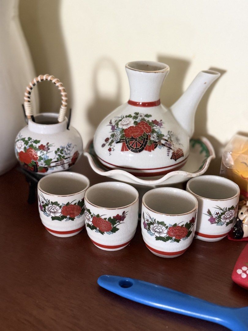 Vintage Japanese Sake Set (Category: Coffee & Tea Tableware) located in Manila. Submitted by ginatan197811 (Listing ID 1421620628, Image 2). Description: - Vintage Japanese sake set - Includes carafe, serving tray, and 4 small cups - Features a beautiful floral design with red and white accents - Carafe has a handle and spout for easy pouring - Cups are perfect for individual servings - Ideal for enjoying sake with friends and family.