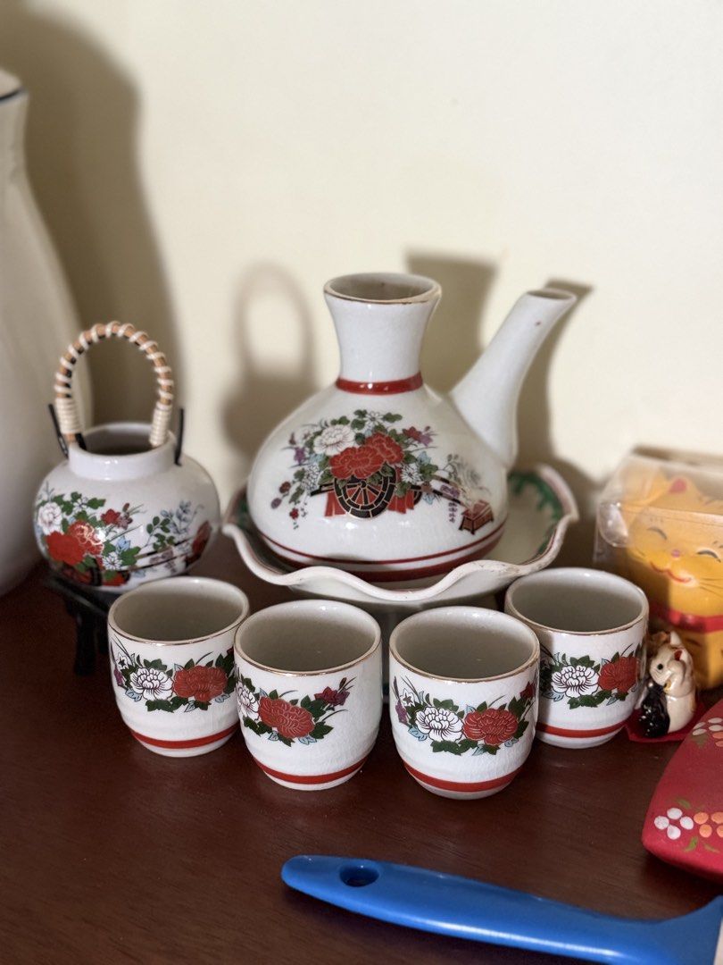 Vintage Japanese Sake Set (Category: Coffee & Tea Tableware) located in Manila. Submitted by ginatan197811 (Listing ID 1421620628, Image 1). Description: - Vintage Japanese sake set - Includes carafe, serving tray, and 4 small cups - Features a beautiful floral design with red and white accents - Carafe has a handle and spout for easy pouring - Cups are perfect for individual servings - Ideal for enjoying sake with friends and family.