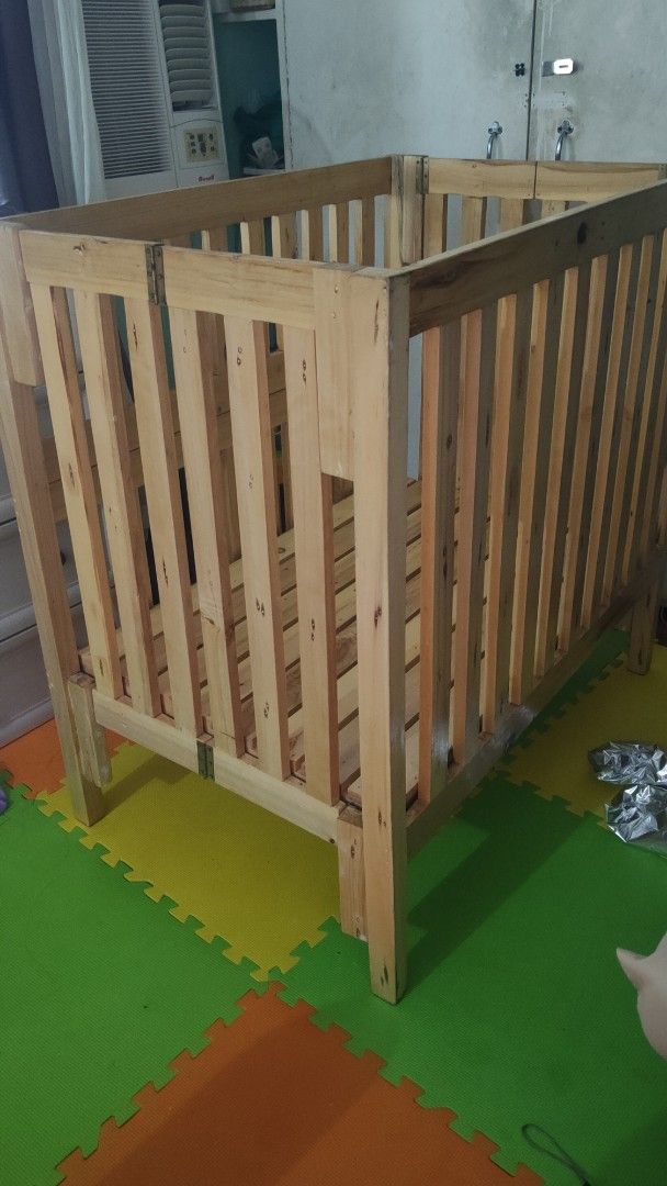 Wooden Baby Crib (Category: Cots & Cribs) located in Manila. Submitted by _sinigurl (Listing ID 1421661443, Image 2). Description: Wooden baby crib. Features a slatted design for ventilation and visibility. Dimensions are approximately 95cm in height, and the base is around 60cm by 100cm. Made of natural wood. Suitable for infants and young children..