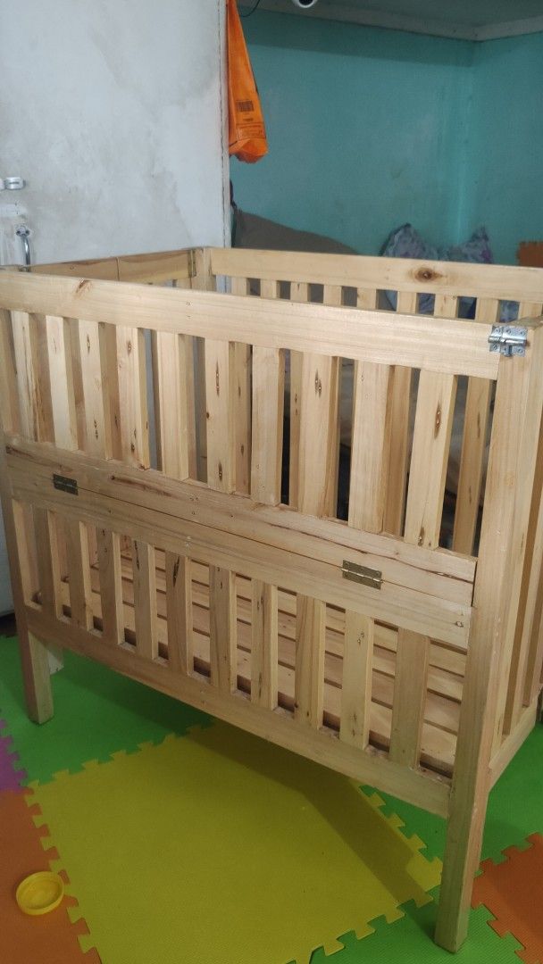 Wooden Baby Crib (Category: Cots & Cribs) located in Manila. Submitted by _sinigurl (Listing ID 1421661443, Image 3). Description: Wooden baby crib. Features a slatted design for ventilation and visibility. Dimensions are approximately 95cm in height, and the base is around 60cm by 100cm. Made of natural wood. Suitable for infants and young children..