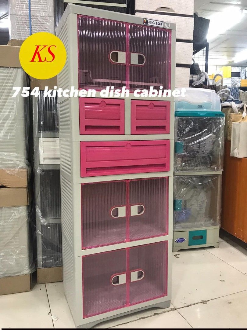 754 Kitchen Dish Cabinet (Category: Other Kitchenware & Tableware) located in Taguig. Submitted by diannecaya86853 (Listing ID 1421917981, Image 3). Description: Kitchen dish cabinet features a pink and white design. It has multiple compartments, including drawers and cabinet spaces. The cabinet is labeled as "Big Box". It is suitable for storing kitchen essentials and dishes. The cabinet has a transparent door design..