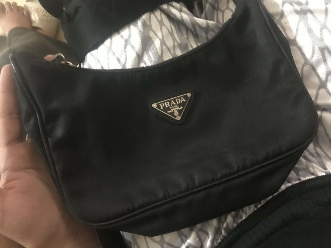 Authentic Prada Nylon Hobo Bag (Category: Luxury Bags & Wallets) located in Manila. Submitted by kaloyyyyyy (Listing ID 1421837348, Image 1). Description: - Authentic Prada hobo bag - Black nylon material - Adjustable strap - Silver Prada triangle logo - Zipper closure - Interior label: "Made in Italy" with serial number - Minor wear on strap.