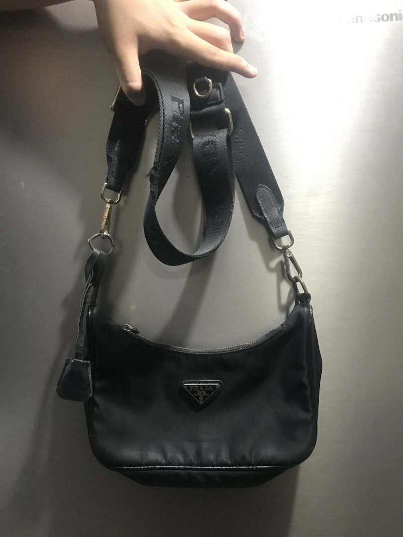 Authentic Prada Nylon Hobo Bag (Category: Luxury Bags & Wallets) located in Manila. Submitted by kaloyyyyyy (Listing ID 1421837348, Image 2). Description: - Authentic Prada hobo bag - Black nylon material - Adjustable strap - Silver Prada triangle logo - Zipper closure - Interior label: "Made in Italy" with serial number - Minor wear on strap.
