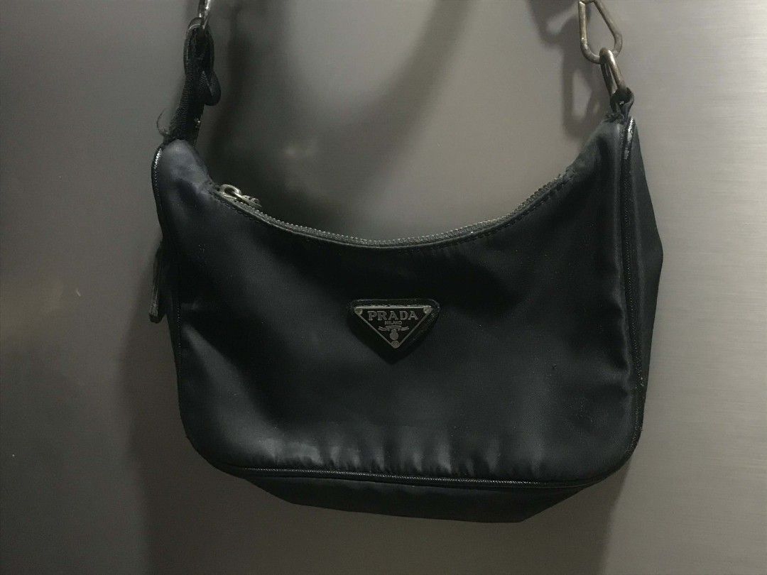 Authentic Prada Nylon Hobo Bag (Category: Luxury Bags & Wallets) located in Manila. Submitted by kaloyyyyyy (Listing ID 1421837348, Image 3). Description: - Authentic Prada hobo bag - Black nylon material - Adjustable strap - Silver Prada triangle logo - Zipper closure - Interior label: "Made in Italy" with serial number - Minor wear on strap.