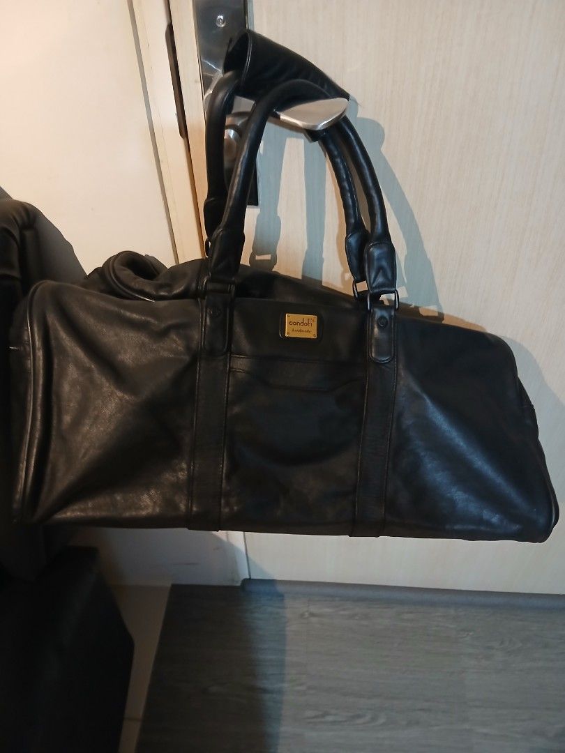 Condotti Black Leather Handbag (Category: Luxury Bags & Wallets) located in Pasay City. Submitted by bespokebyhypeves (Listing ID 1421918780, Image 2). Description: - Black leather handbag - Double handles - Rectangular shape - Zipper closure - Gold-colored tag - Strap detail on front and back.