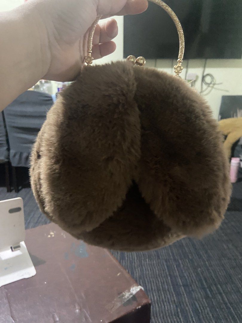 Brown Furry Handbag with Gold Handle (Category: Luxury Bags & Wallets) located in Pasig City. Submitted by khloe23 (Listing ID 1421851089, Image 1). Description: - Soft, brown furry exterior - Gold-colored handle - Unique round shape - Kiss-lock closure - Smooth, neutral-colored interior lining - Sturdy, circular handle - Perfect for adding flair to your look.