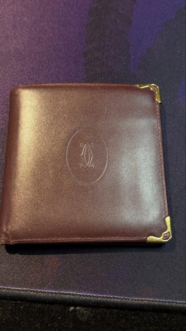 Cartier Leather Wallet (Category: Luxury Bags & Wallets) located in Capas. Submitted by silvertiger_130b66 (Listing ID 1421800334, Image 1). Description: - Cartier burgundy leather wallet - Embossed Cartier logo - Multiple card slots - Bill compartment - Repeating Cartier logo lining - Gold-colored corner accents.
