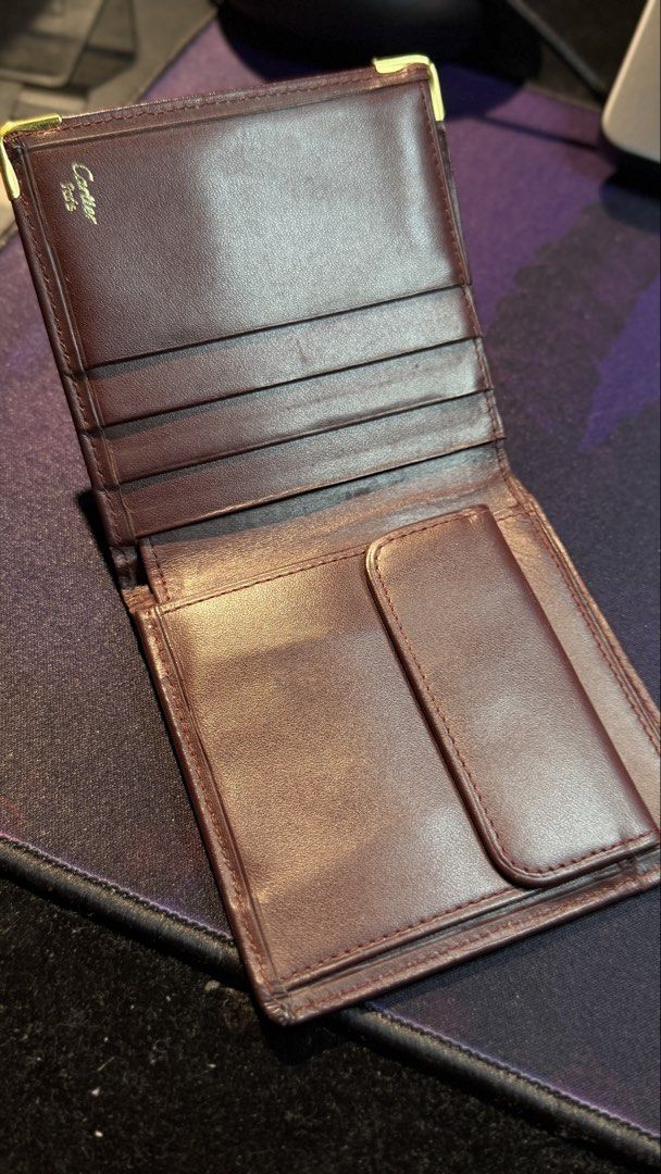 Cartier Leather Wallet (Category: Luxury Bags & Wallets) located in Capas. Submitted by silvertiger_130b66 (Listing ID 1421800334, Image 2). Description: - Cartier burgundy leather wallet - Embossed Cartier logo - Multiple card slots - Bill compartment - Repeating Cartier logo lining - Gold-colored corner accents.
