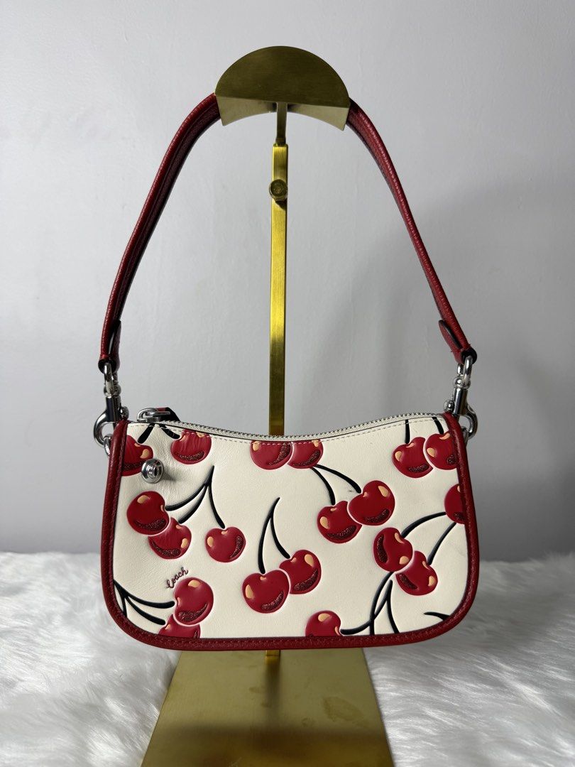 Coach Floral Printed Leather Swing 20 Handbag (Category: Luxury Bags & Wallets) located in Makati City. Submitted by khriz_terrado (Listing ID 1421923706, Image 2). Description: limited Edition Cherry Print - Coach Swing 20 handbag - Playful cherry print - Red leather strap and trim - Secure zip closure - Features a small Coach logo detail - Designed for shoulder wear - Excellent to new condition No hangtag.