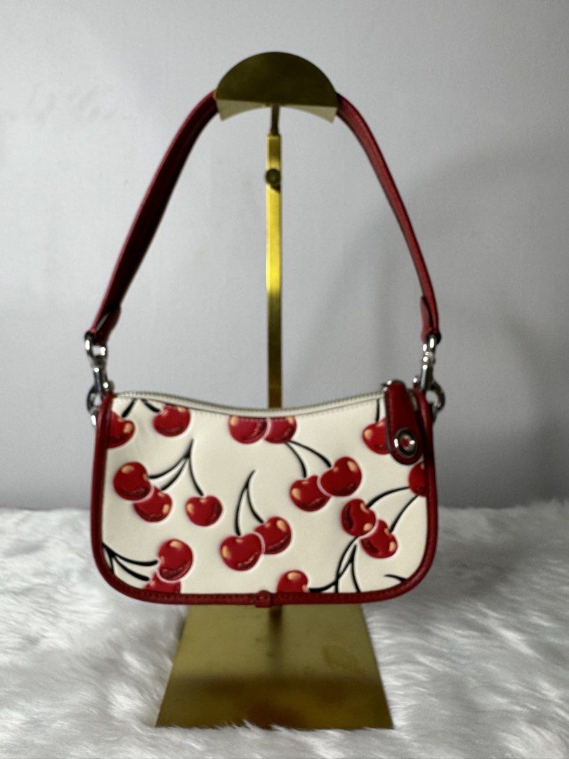 Coach Floral Printed Leather Swing 20 Handbag (Category: Luxury Bags & Wallets) located in Makati City. Submitted by khriz_terrado (Listing ID 1421923706, Image 1). Description: limited Edition Cherry Print - Coach Swing 20 handbag - Playful cherry print - Red leather strap and trim - Secure zip closure - Features a small Coach logo detail - Designed for shoulder wear - Excellent to new condition No hangtag.