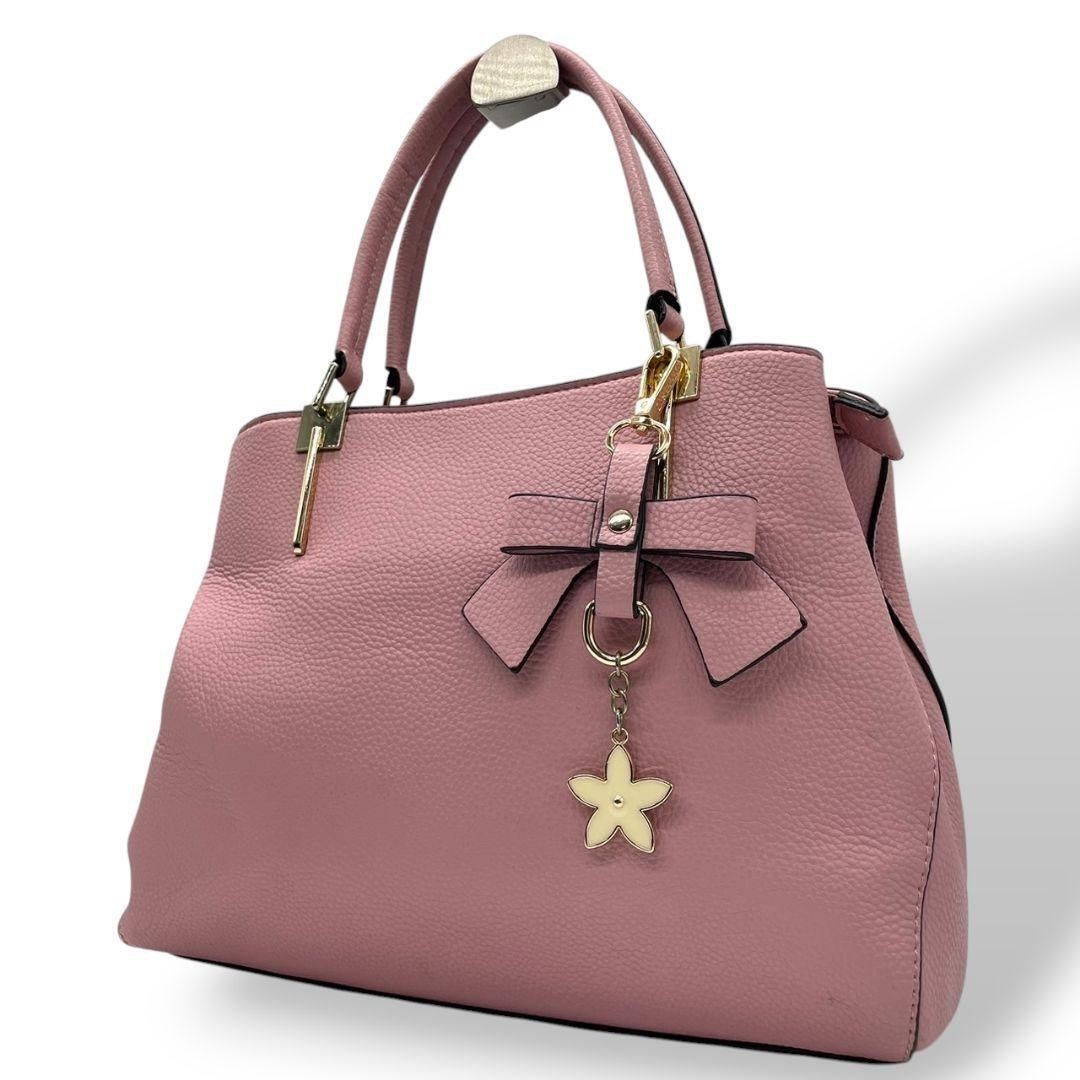 D. Kelly Japan Handbag (Category: Luxury Bags & Wallets) located in Manila. Submitted by tmyjapanfinds2022 (Listing ID 1421904692, Image 1). Description: - Brand: D. Kelly Japan - Color: Pink - Features: Bow detail, two handles, detachable flower charm - Compartments: Zippered main compartment, inner zippered pocket - Condition: Good.