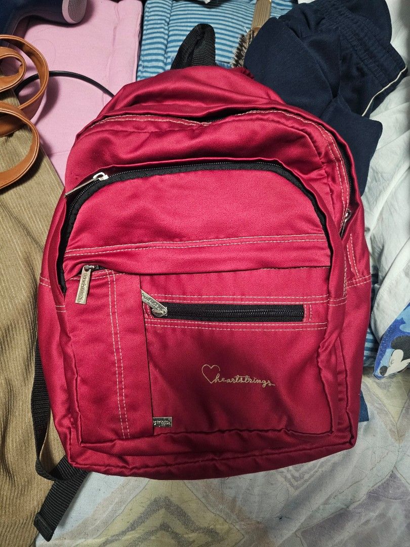 Heartstrings Red Backpack (Category: Backpacks) located in Antipolo. Submitted by 1ceb3rg (Listing ID 1421821448, Image 1). Description: - Red Heartstrings backpack - Multiple zippered compartments for storage - Adjustable shoulder straps - Top handle - Durable, possibly water-resistant material - Classic design, perfect for everyday use.