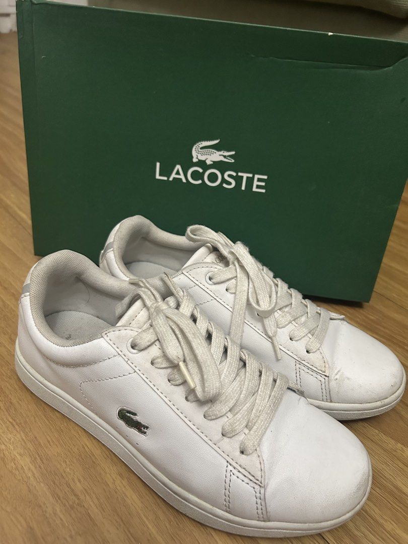 Lacoste White Sneakers (Category: Sneakers) located in Marikina City. Submitted by fm.ty (Listing ID 1421851555, Image 1). Description: White Lacoste sneakers with the iconic crocodile logo. Features a classic lace-up design. Includes the original green Lacoste box. The sneakers have a white upper and a white sole. The Lacoste logo is visible on the side and the heel of the shoes. Original Price: Php 6,500.