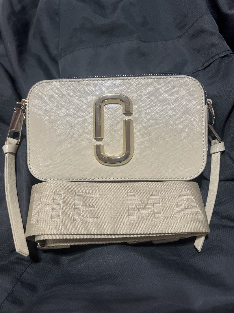 Marc Jacobs The Snapshot Crossbody Bag (Category: Luxury Bags & Wallets) located in Taguig. Submitted by stuffitlikeitshot (Listing ID 1421883505, Image 1). Description: - Guaranteed ORIG from CA - Wide, branded, detachable strap - Double-zip closure - Exterior back pocket - Interior small pocket - Neutral color - Gold-tone hardware - FLAW- lipstick stain (last pic).