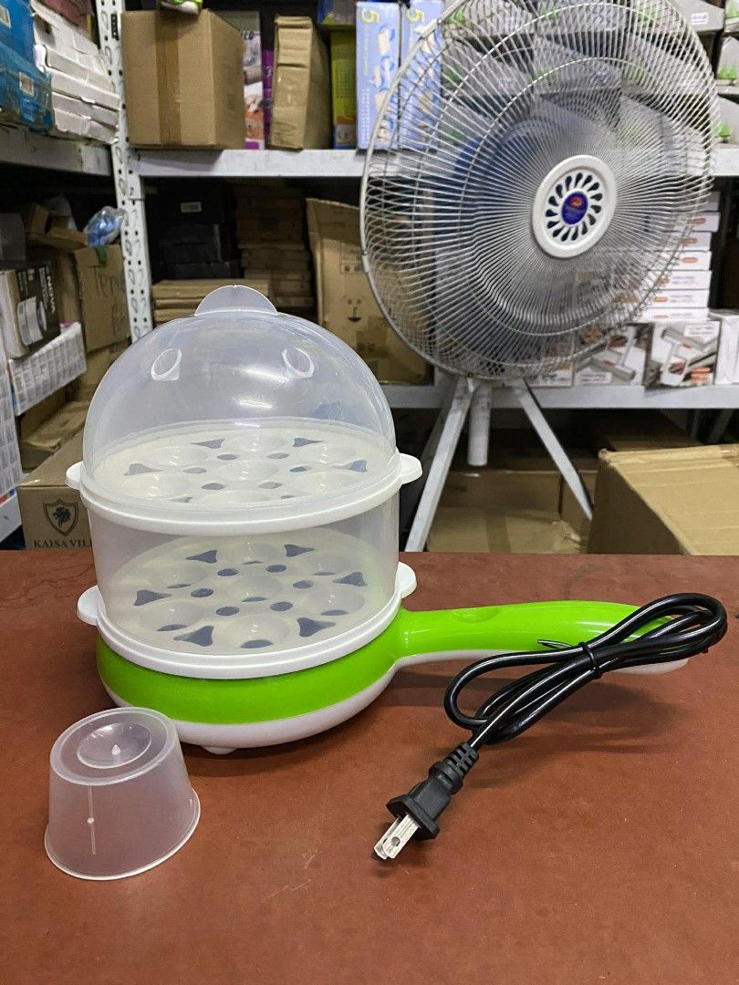 Multifunctional Magic Pot Steamed/Boiled Egg Cooker (Category: Cookers) located in Manila. Submitted by lyfrancois14 (Listing ID 1421857255, Image 2). Description: - Multifunctional magic pot for steaming and boiling eggs - Includes clear lid - Comes with egg holders - Features a small measuring cup - Includes a small frying pan attachment - Stylish green and white design with a pink handle - Ideal for quick and easy egg preparation.