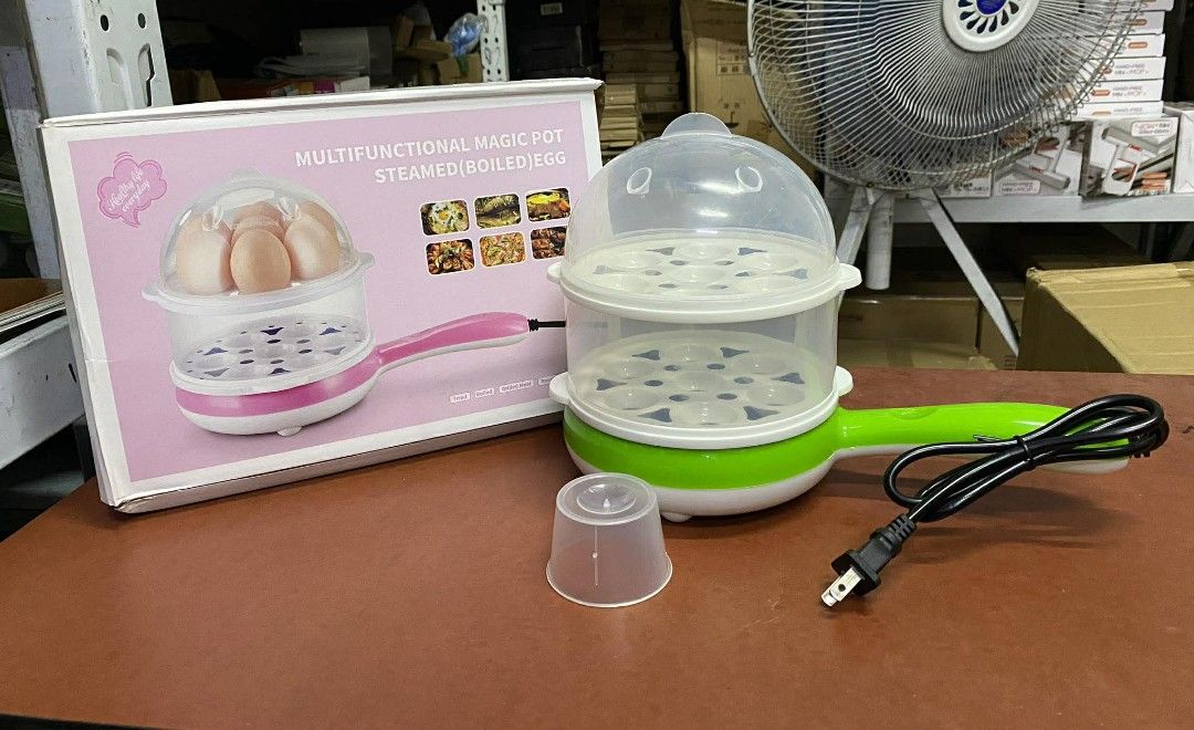 Multifunctional Magic Pot Steamed/Boiled Egg Cooker (Category: Cookers) located in Manila. Submitted by lyfrancois14 (Listing ID 1421857255, Image 1). Description: - Multifunctional magic pot for steaming and boiling eggs - Includes clear lid - Comes with egg holders - Features a small measuring cup - Includes a small frying pan attachment - Stylish green and white design with a pink handle - Ideal for quick and easy egg preparation.