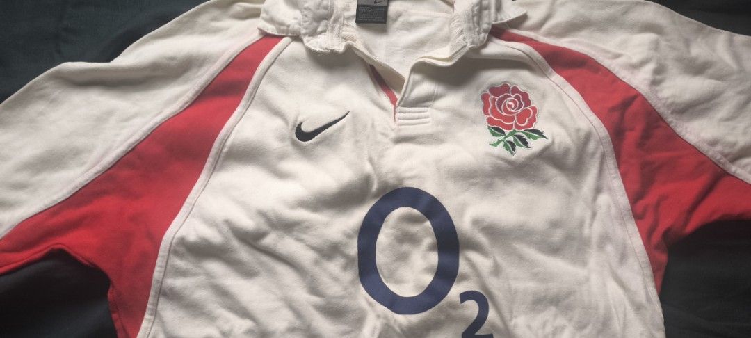 Nike England Rugby Jersey （分類：運動服裝）位於 Hong Kong。 由 peterthepainter 提交（商品編號 1421863920，圖片 2）。簡介： Authentic England rugby jersey. Features the iconic red rose emblem and the O2 logo. Made by Nike. The jersey has a white base with red accents on the shoulders. Includes a Nike logo on the chest. The tag indicates it was made in Sri Lanka.。