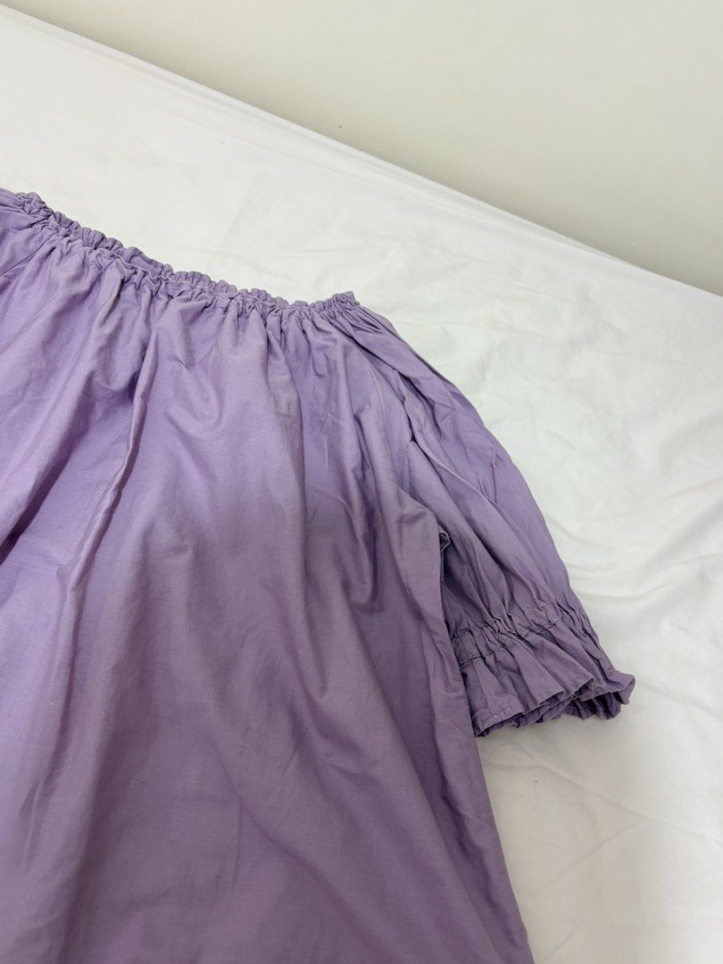 Off-Shoulder Blouse - Lavender (Category: Blouses) located in Baguio. Submitted by declutterbyshy (Listing ID 1421930608, Image 2). Description: - Off-shoulder design - Light lavender fabric - Relaxed fit - Short sleeves with ruffled cuffs - Gathered neckline - Perfect for casual wear.