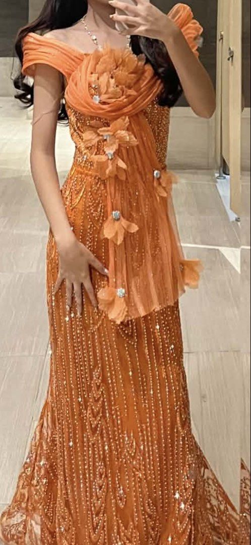 Rustic Orange Evening Gown for Rent (Category: Evening dresses & gowns) located in Pateros City. Submitted by superroxy (Listing ID 1421885405, Image 2). Description: - Elegant orange evening gown - Unique off-shoulder design - Intricate bodice detailing - Flowing skirt - Embellished - Fitted silhouette - Includes a black clutch - Ideal for special occasions.