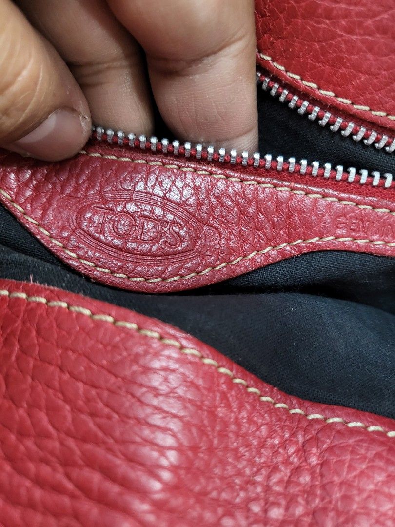 Tod's Red Leather Handbag (Category: Luxury Bags & Wallets) located in Manila. Submitted by eljayminati (Listing ID 1421932890, Image 2). Description: - Authentic Tod's handbag - Red leather - Top handle design - Buckle closure - Zipper closure - Black interior lining - Tod's logo present - Textured leather finish.