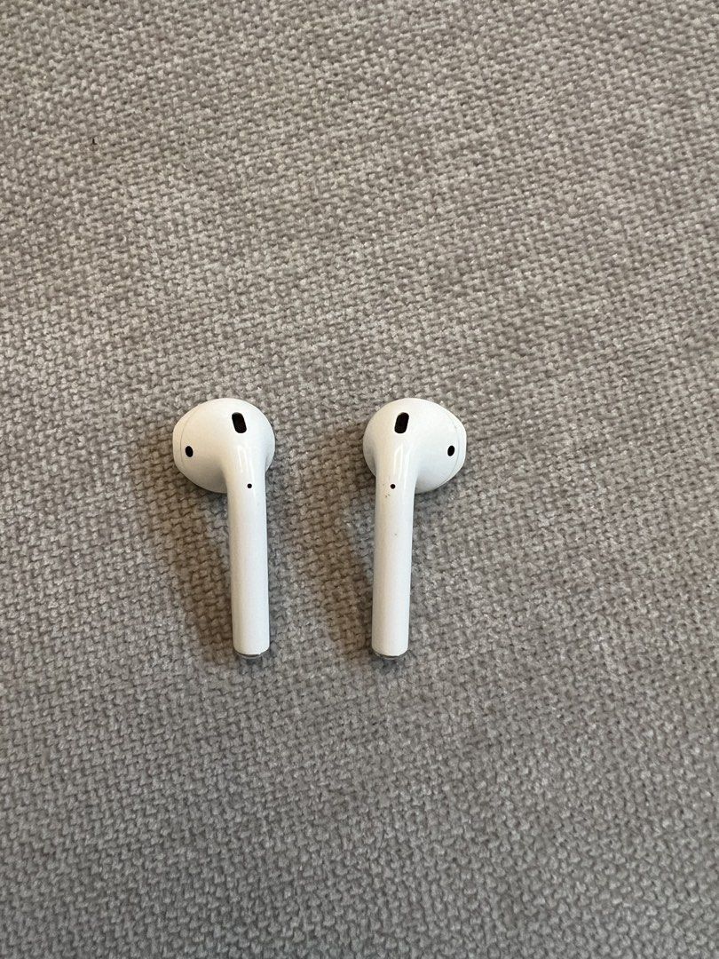 Apple AirPods Gen 2 (Category: Earphones) located in Muntinlupa City. Submitted by cjcv0 (Listing ID 1422045924, Image 2). Description: - Includes left and right AirPods and charging case - White color - Smooth, glossy finish on the case - Stem design for AirPods - Case has a hinge for opening and closing.
