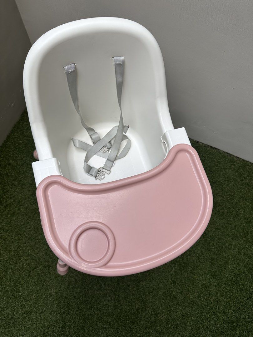 Baby High Chair with Tray (Category: Baby High Chairs) located in Paranaque City. Submitted by every_thingph (Listing ID 1421954324, Image 3). Description: - White and pink high chair - Designed for babies and toddlers - Removable tray for easy cleaning - Includes a safety harness for security - Convenient storage basket - Easy-to-clean plastic seat - Comfortable footrest - Pink accents on legs.