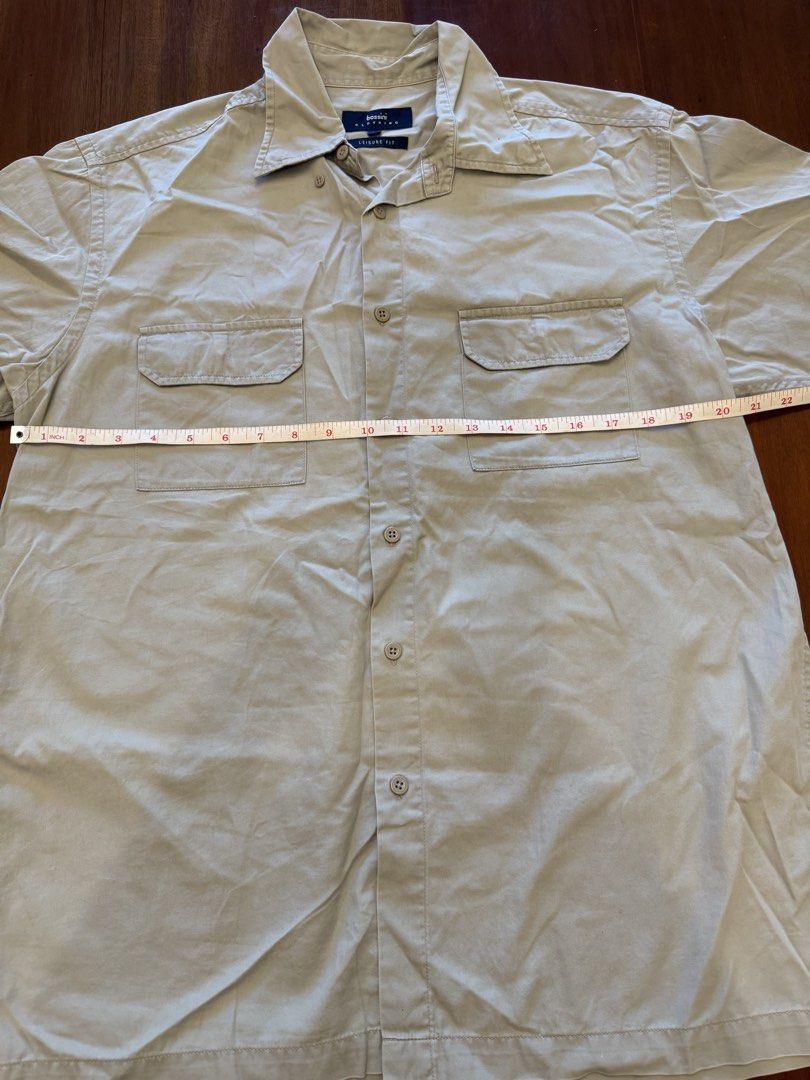 Bossini Leisure Fit Shirt - Medium (Category: Shirts) located in Mandaue City. Submitted by marginiz (Listing ID 1421953577, Image 3). Description: Bossini Leisure Fit shirt in size Medium. Features a button-down closure, two chest pockets, and short sleeves. The shirt is a neutral beige color. Measurements are approximately 29 inches in length and 20 inches across the chest. Made of a comfortable fabric suitable for casual wear..