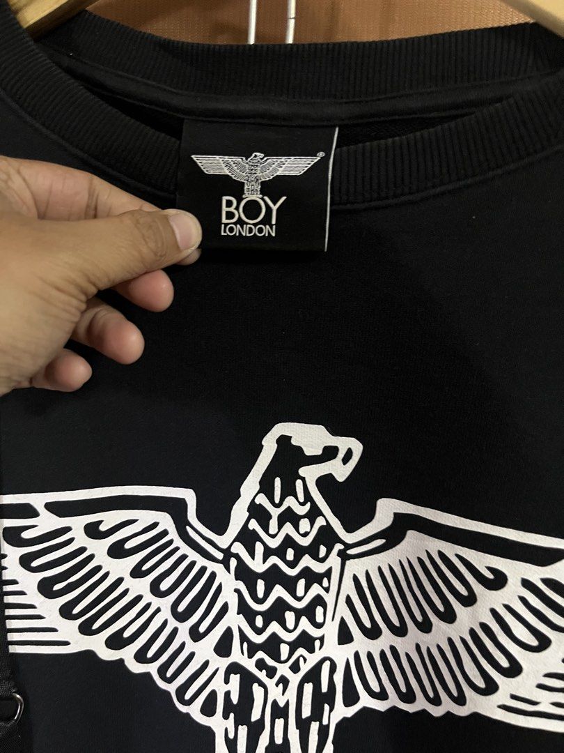 BOY London Black Eagle Logo Sweatshirt with Straps (Category: Coats, Jackets and Outerwear) located in Paranaque City. Submitted by mondaysglory (Listing ID 1422068035, Image 3). Description: BOY London Black Eagle Logo Sweatshirt with Straps L - 26 W - 22 Color rate: 9.5/10 Condition: Very Good Need wash - Black Boy London sweatshirt - Features an eagle graphic and "BOY" print - Decorative straps - Size: XS - Back: Vertical strap and Boy London 
