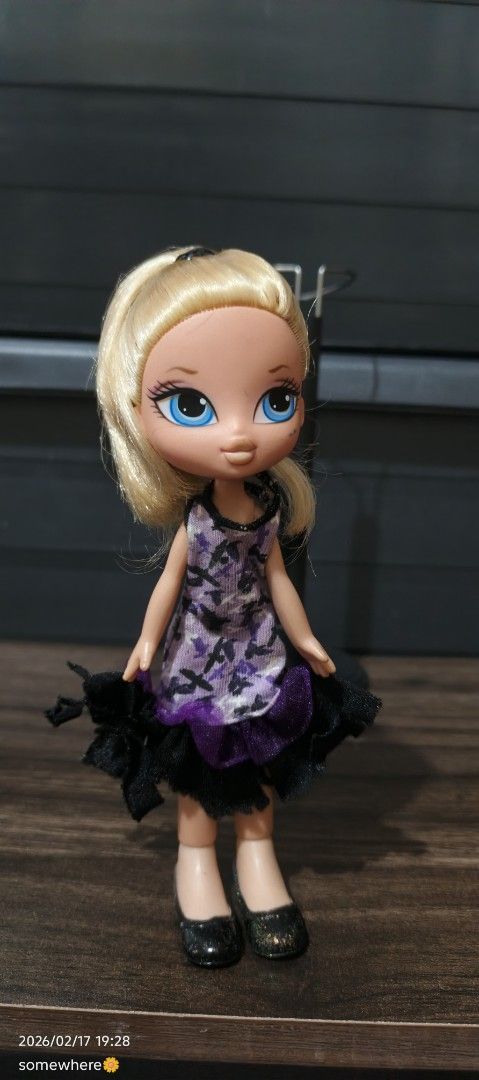 Bratz Lil' Angelz Doll (Category: Kids Toys) located in Manila. Submitted by alhaina (Listing ID 1422035445, Image 1). Description: - Bratz Lil' Angelz doll - Features blonde hair and blue eyes - Wearing a purple and black dress with matching shoes.