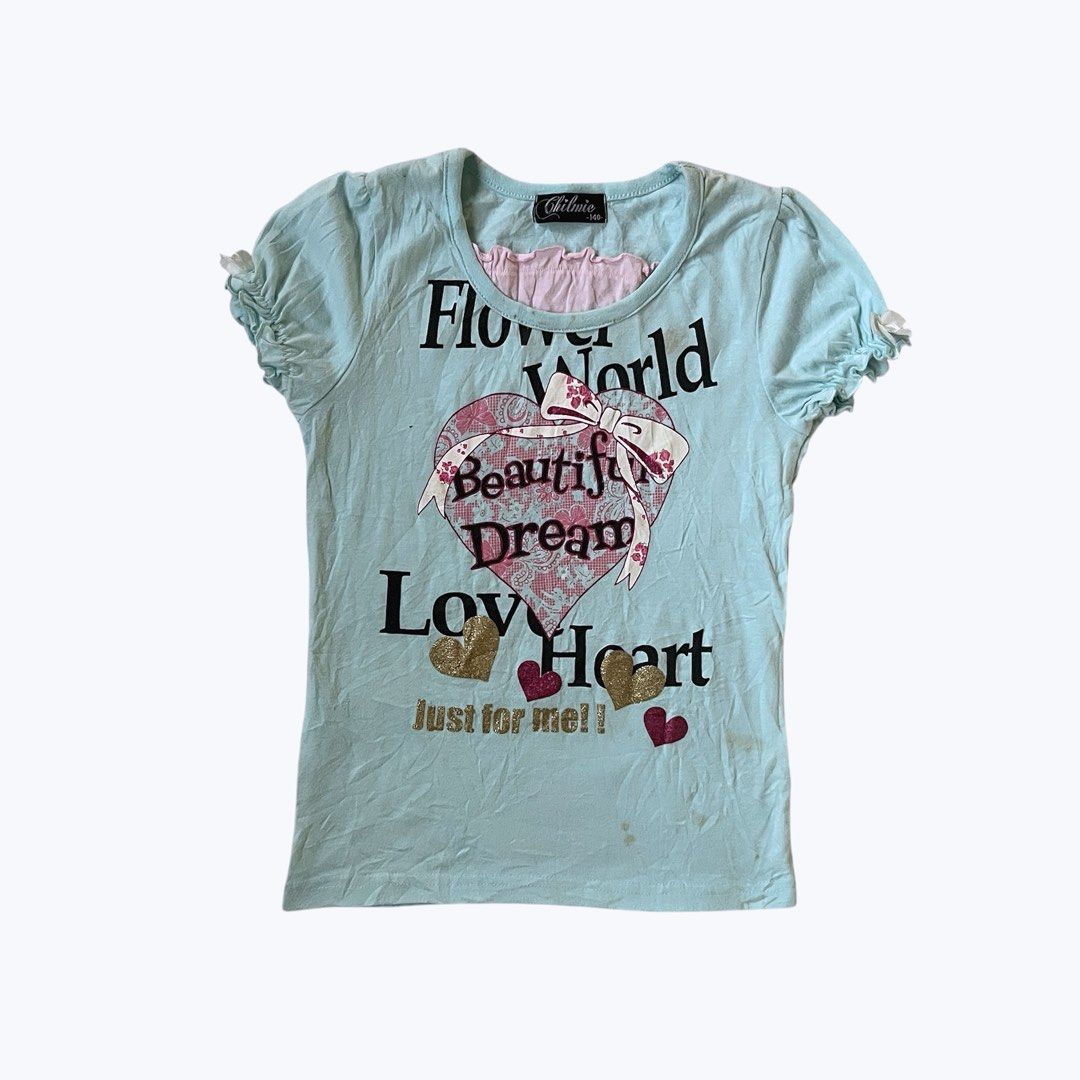 Chilmie Flower World Graphic Baby Tee (Category: Shirts) located in Manila. Submitted by meeeeeraaa (Listing ID 1422020160, Image 1). Description: Chilmie t-shirt with a light blue base, 'Flower World' graphic, ruffled sleeves, and pink inner layer. Features a heart design with glitter. Note: Visible stains on the front and sides. FREE FOR MINERS.