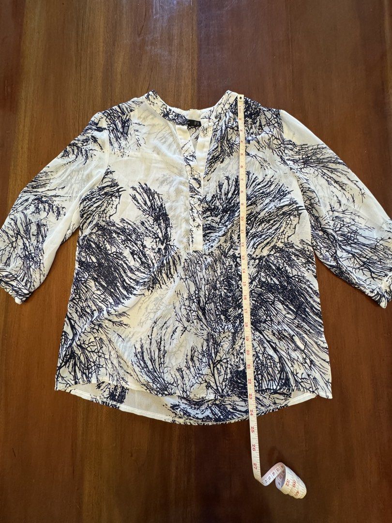 Forme Printed Blouse - Size M (Category: Blouses) located in Mandaue City. Submitted by marginiz (Listing ID 1421952508, Image 2). Description: Elegant blouse from Forme, featuring a unique print in white and navy. It has a mandarin collar and three-quarter sleeves. The blouse measures approximately 27 inches in length and 20 inches across the chest. Size M, as indicated on the label. A stylish addition to any wardrobe..