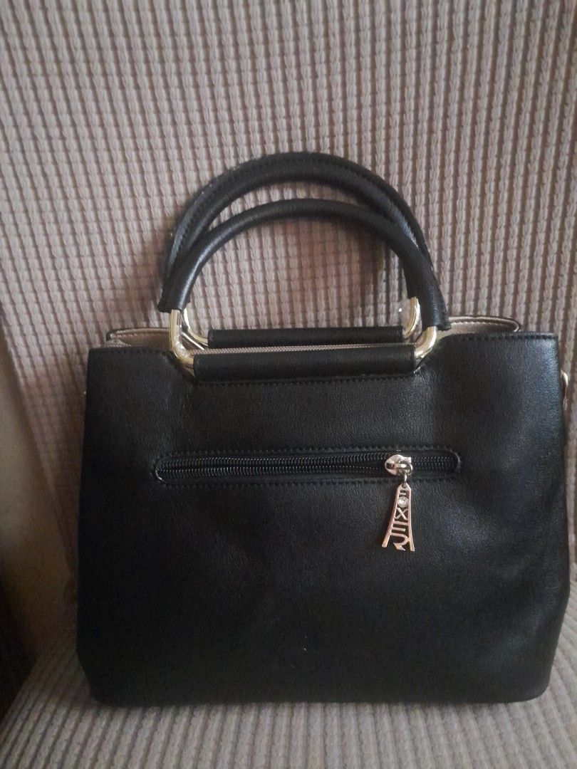 Foxer Black Handbag with Bow Detail (Category: Luxury Bags & Wallets) located in Quezon City. Submitted by lalaine.r (Listing ID 1421952012, Image 2). Description: - Foxer black handbag - Stylish bow detail - Top handle - Back zippered pocket - Spacious interior with small inner pocket - Gold-toned hardware - Structured design - Perfect for everyday or special occasions - Issue: Missing Sling.